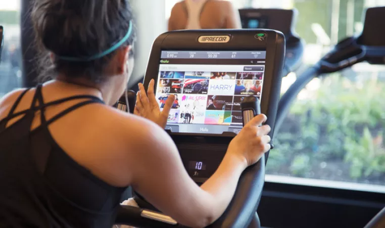 Woman using exercise equipment with digital screen